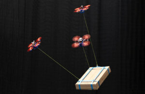Three drones work together to carry a package using a new algorithm developed at TU Delft.