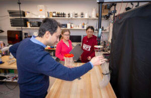 WPI researchers interacting with their origami-inspired robotic arm.
