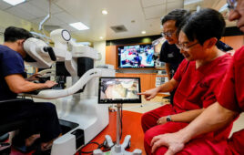 Surgeons from NUH and FHU demonstrating how the console unit in Singapore controls the four robotic arms in Nagoya, Japan.