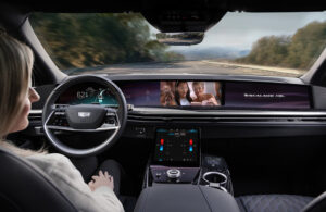 A person driving in a self driving car watching a video.
