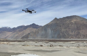 A Raphe mPhibr drone flying over a desert with a mountain in the distance.