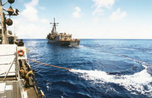 A view taken from onboard the US Navy (USN) Cyclone Class Coastal Defense Ship, USS HURRICANE (PC 3), showing as a trailing refueling line being extended from the USN Oliver Hazard Perry Class: Guided Missile Frigate, USS JOHN H. SIDES (FFG 14), as the two ships conduct Replenishment At Sea (RAS) operations while underway in the Pacific Ocean participating in a Coordination Afloat Readiness and Training (CARAT) Exercise, while executing the first trans-Pacific cruise of a Patrol Forces boat.