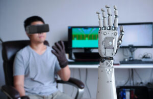 A man using teleoperation technology to control a robot hand.